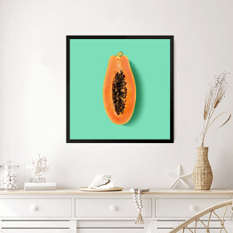 Obraz w ramie Przekrojona papaya na miętowym tle