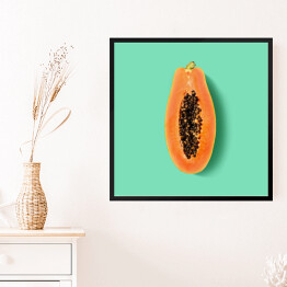 Obraz w ramie Przekrojona papaya na miętowym tle