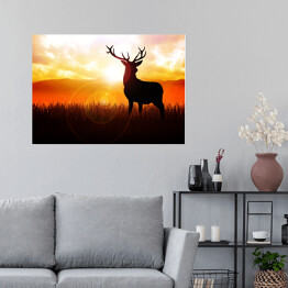 Plakat Postać jelenia na tle zachodzącego słońca