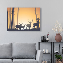 Obraz na płótnie Dzikie zwierzęta w lesie na tle zachodzącego słońca