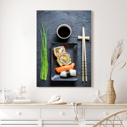Obraz na płótnie Świeże sushi, ciemna ceramika i pałeczki do jedzenia
