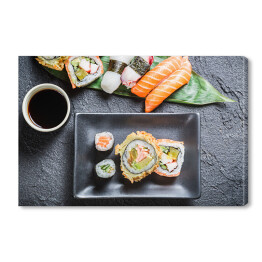 Obraz na płótnie Sushi z sosem sojowym na czarnej skale