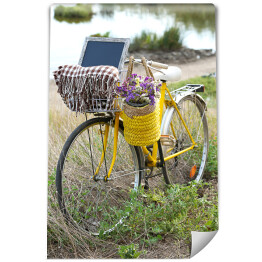 Fototapeta winylowa zmywalna Bicykl z koszem z kwiatami na łące podczas zmierzchu