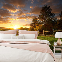 Fototapeta samoprzylepna Malowniczy krajobraz, ogrodzone ranczo o wschodzie słońca