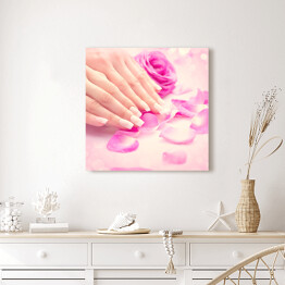 Obraz na płótnie Kobiece dłonie w różowych płatkach róż