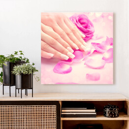 Obraz na płótnie Kobiece dłonie w różowych płatkach róż