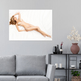 Plakat samoprzylepny Młoda wysoka kobieta leżąca na łóżku