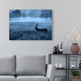 Obraz na płótnie Krajobraz z jeleniem na polanie we mgle o zmierzchu