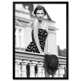 Plakat w ramie Młoda kobieta na balkonie. Czarno biała fotografia