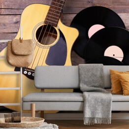 Fototapeta Gitara i winylowe płyty na drewnianym stole