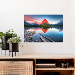 Plakat Czerwona góra i jej lustrzane odbicie w jeziorze - widok z brzegu usłanego kamieniami