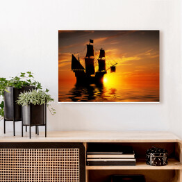 Obraz klasyczny Stary piracki statek na tle złocistego zachodu słońca