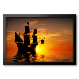 Obraz w ramie Stary piracki statek na tle złocistego zachodu słońca