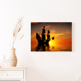 Obraz klasyczny Stary piracki statek na tle złocistego zachodu słońca