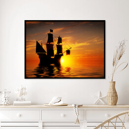 Plakat w ramie Stary piracki statek na tle złocistego zachodu słońca
