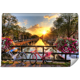 Fototapeta samoprzylepna Most z rowerami i kwiatami na tle pięknego wschodu słońca, Amsterdam, Holandia