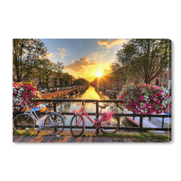 Obraz na płótnie Most z rowerami i kwiatami na tle pięknego wschodu słońca, Amsterdam, Holandia