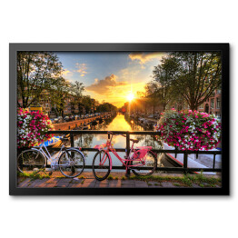 Obraz w ramie Most z rowerami i kwiatami na tle pięknego wschodu słońca, Amsterdam, Holandia