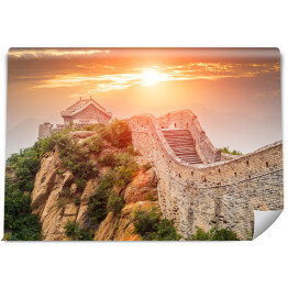 Fototapeta Wielki Mur w Pekinie oświetlony złocistym światłem słonecznym podczas zmierzchu, Chiny