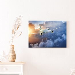 Obraz na płótnie Samolot wśród chmur w blasku słońca