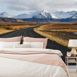 Fototapeta samoprzylepna Islandzka pusta droga na tle gór zimą