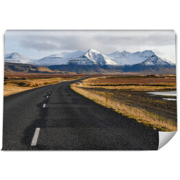 Fototapeta Islandzka pusta droga na tle gór zimą