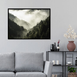 Plakat w ramie Wysoka góra porośnięta drzewami w mgle i chmurze