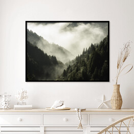 Plakat w ramie Wysoka góra porośnięta drzewami w mgle i chmurze