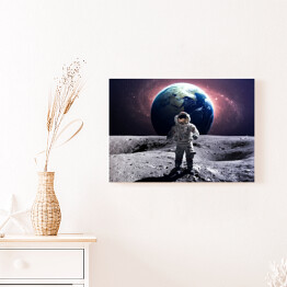 Obraz na płótnie Astronauta na spacerze kosmicznym na księżycu na tle planety