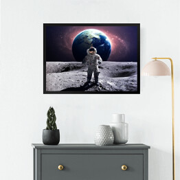 Obraz w ramie Astronauta na spacerze kosmicznym na księżycu na tle planety