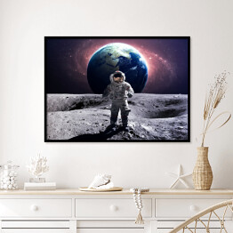 Plakat w ramie Astronauta na spacerze kosmicznym na księżycu na tle planety