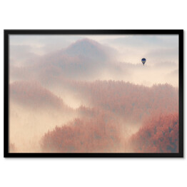 Plakat w ramie Samotny balon lecący nad lasem spowitym mgłą